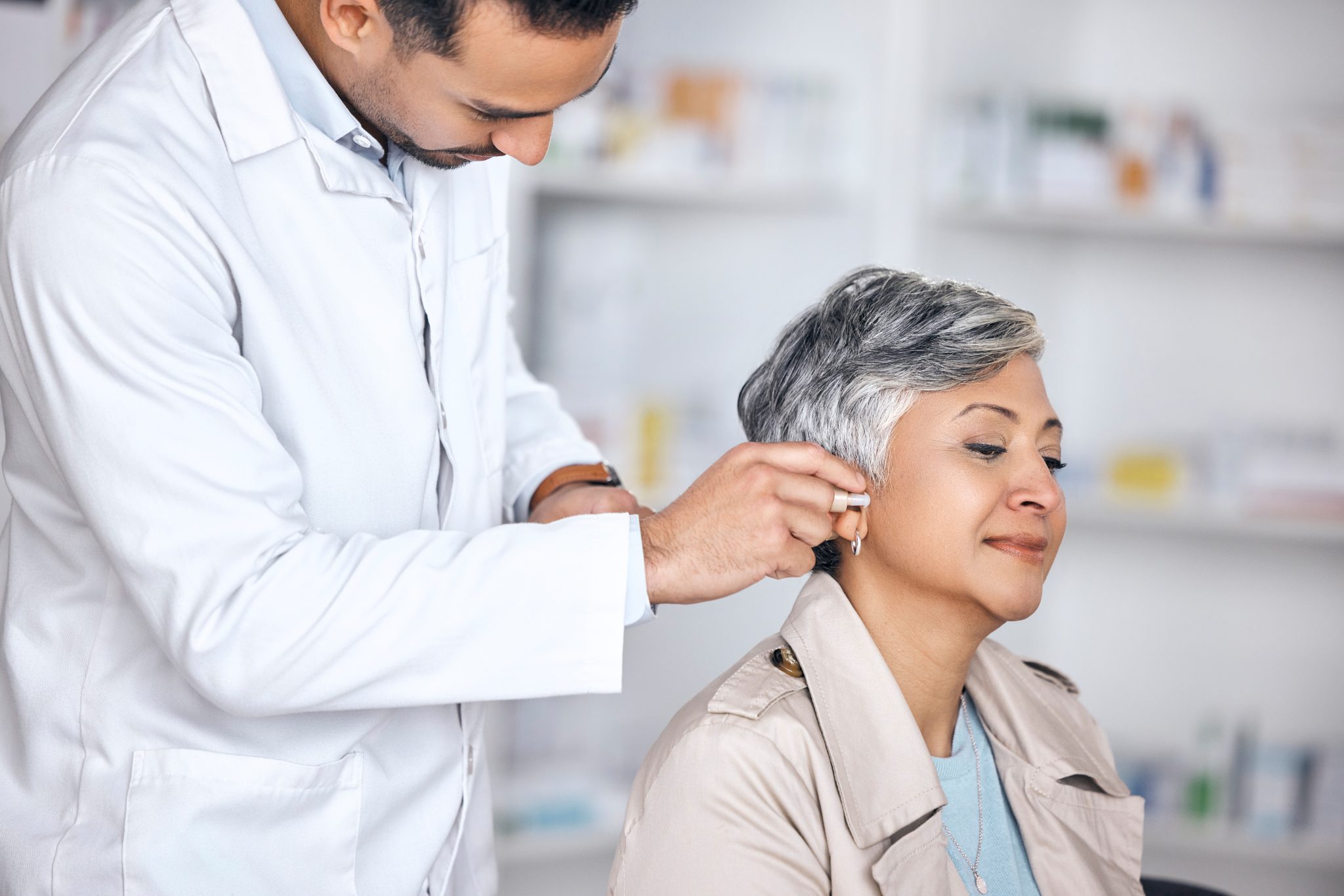 doctor helping a middle aged woman put on cochlear implant