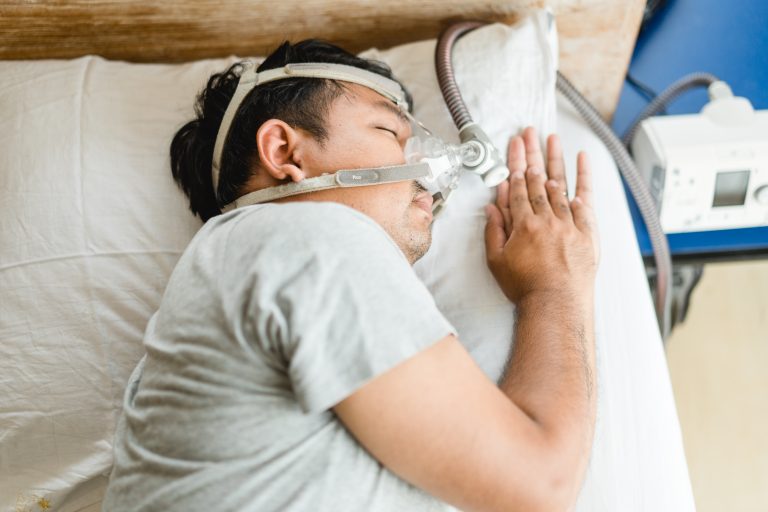 asian man wearing cpap mask sleeping in bed and snoring